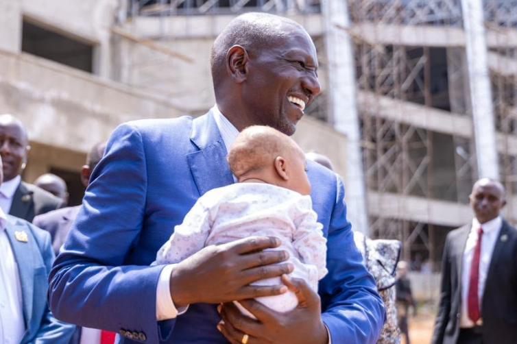 A file photo of President William Ruto holding a baby during his Eldoret visit.